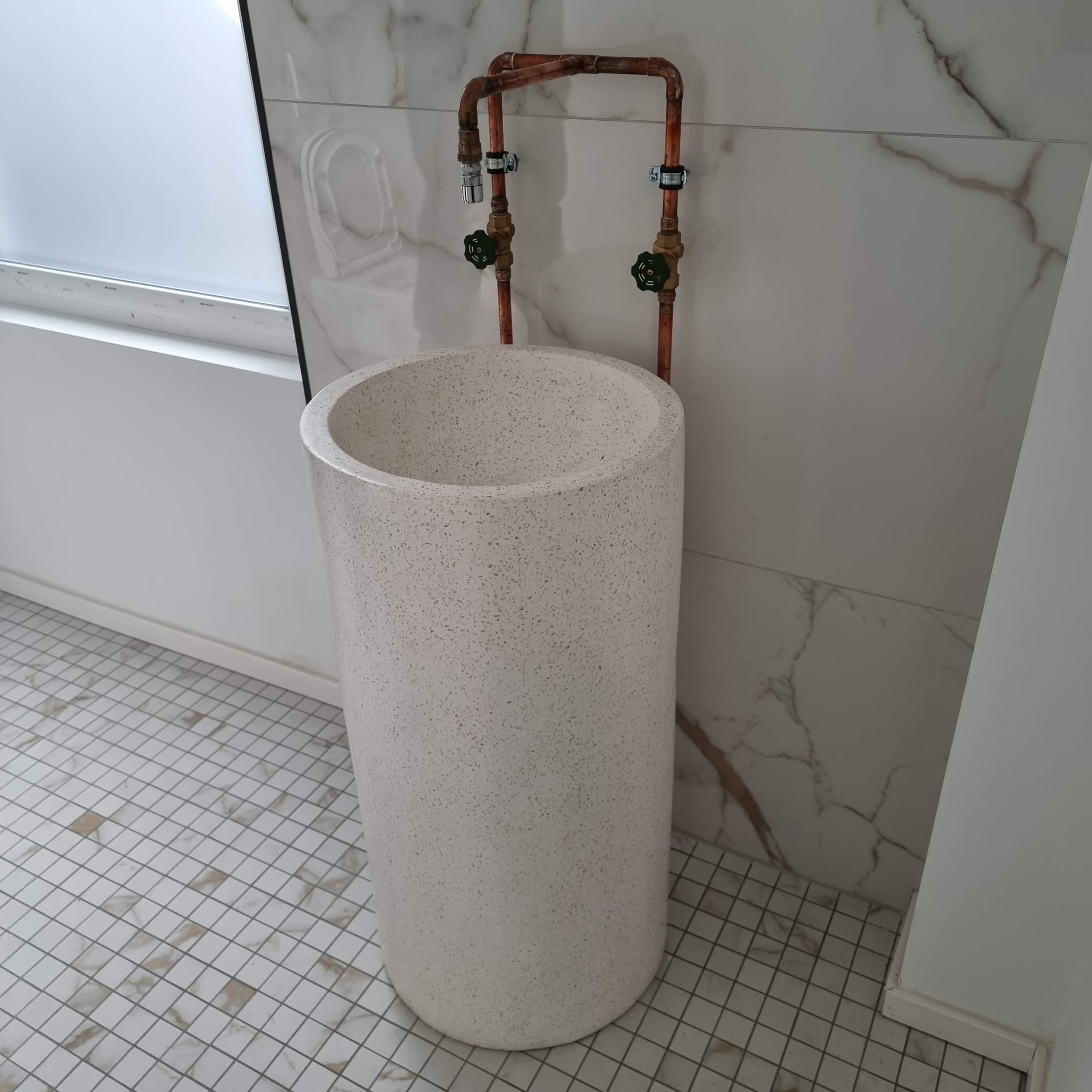 A large round washbasin made of white stone