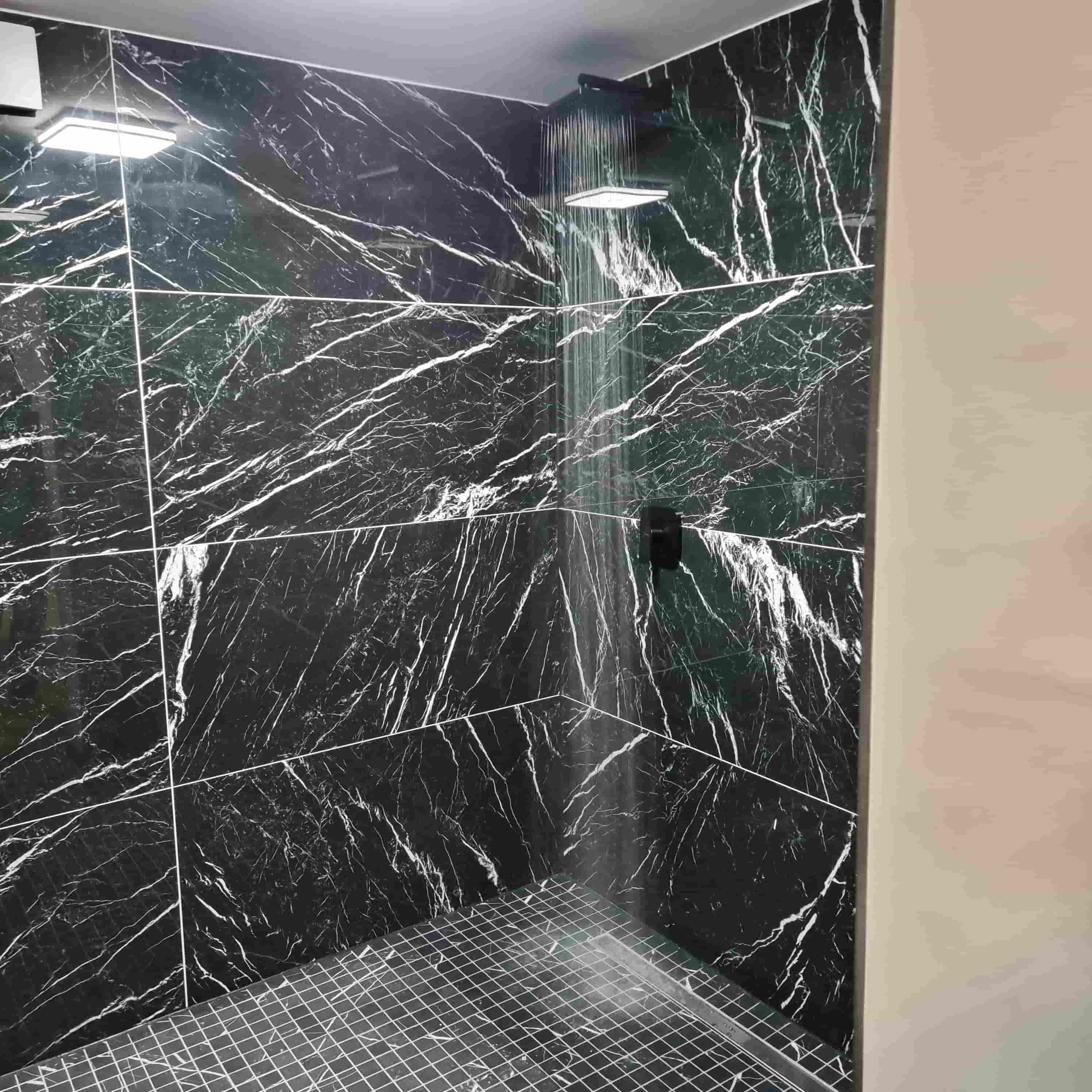 A shower with big black marbletiles