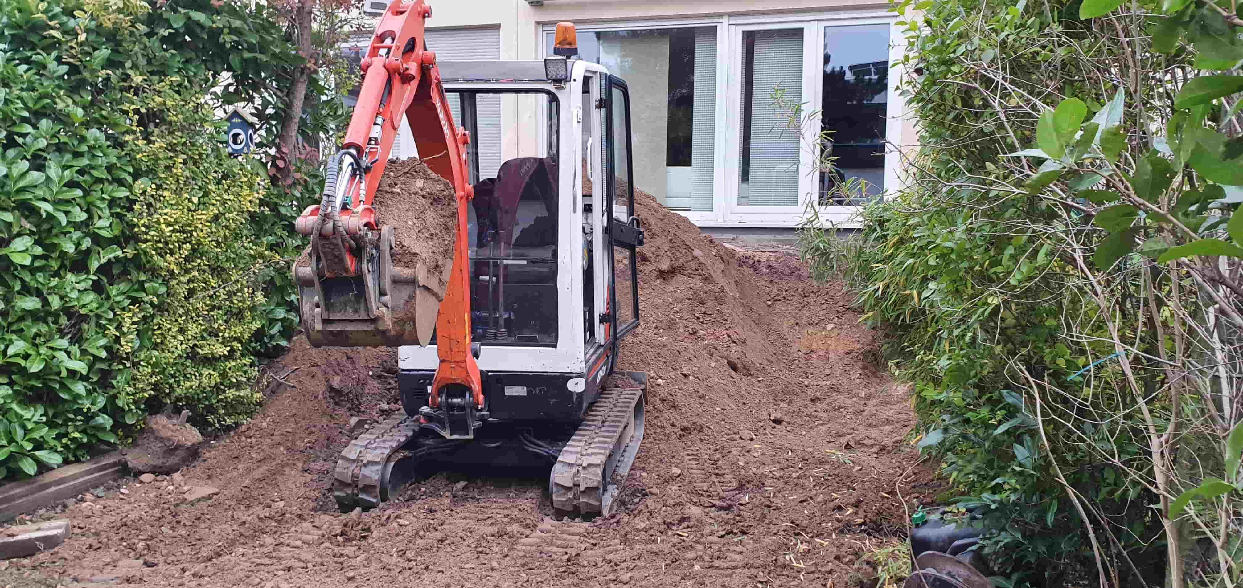 Ein orangener Bagger von Guido Breitbach während der Arbeit.