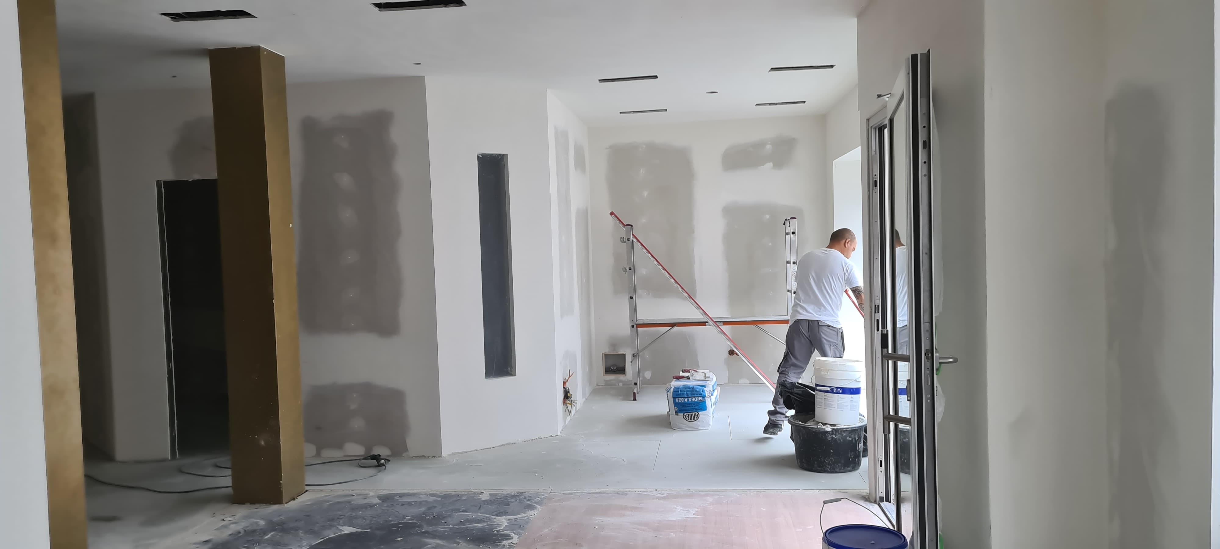 Eine Kernsanierung mitten im Prozess. Man sieht einen Mitarbeiter von Guido Breitbach der gerade am Putzen ist.