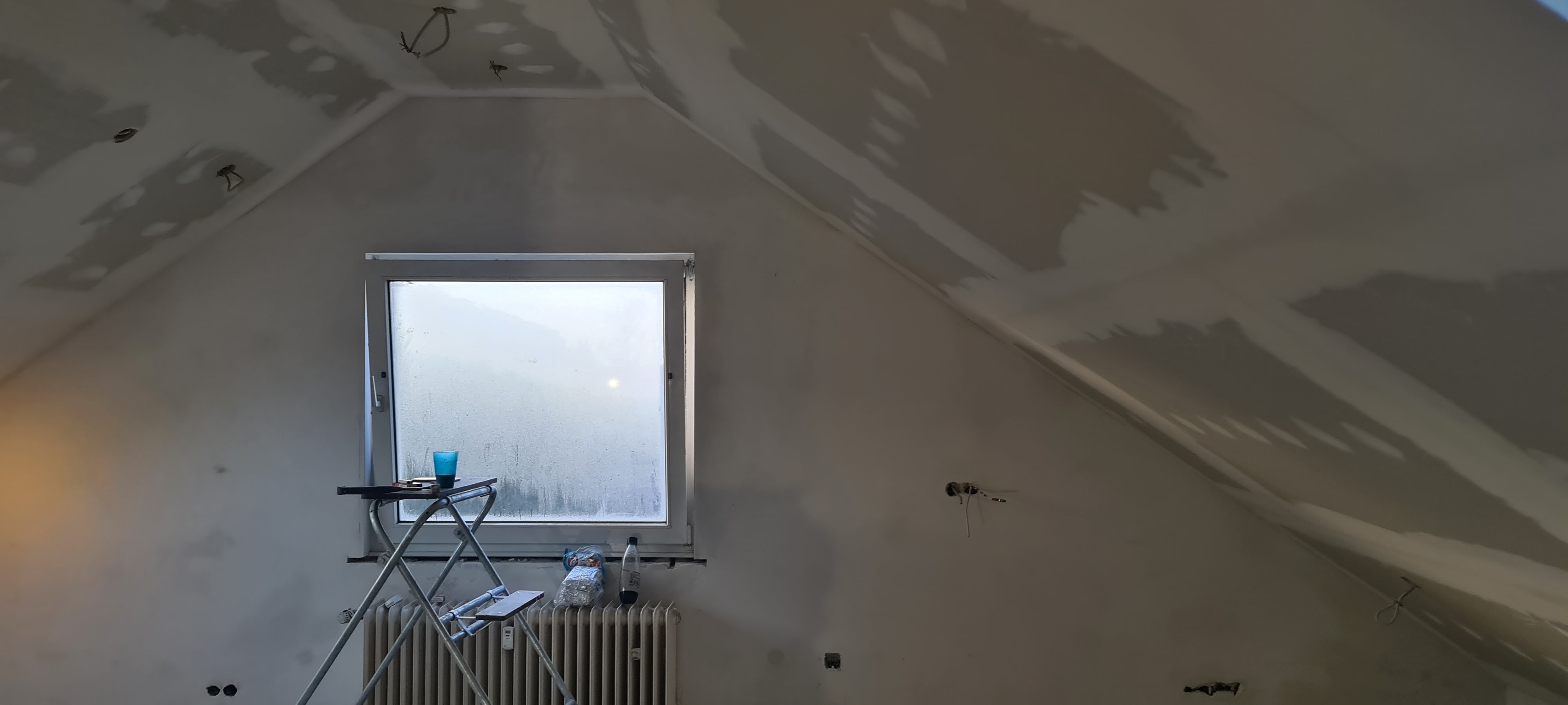 fast fertiger Dachboden mit der Aussicht auf ein Fenster.